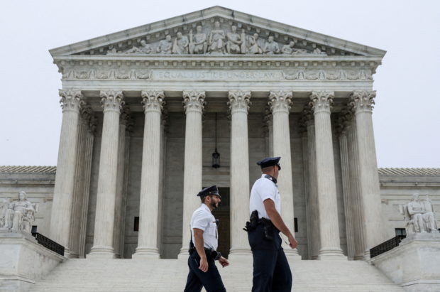 FILE PHOTO: Police officers walk outside the U.S. Supreme Court in Washington, U.S., May 3, 2022. REUTERS/Evelyn Hockstein/File Photo