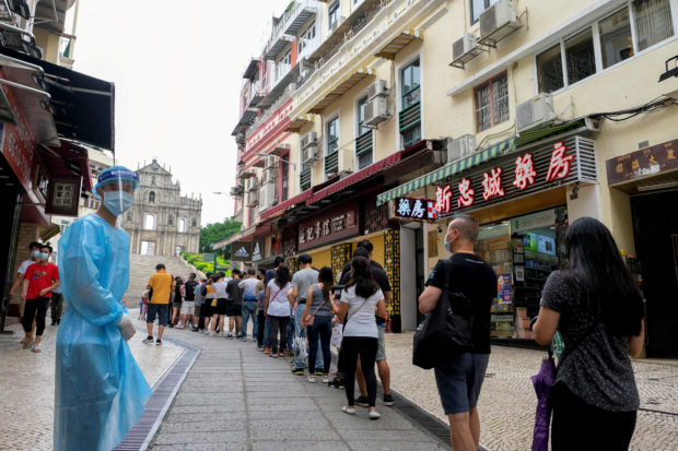 FILE PHOTO: People queue for COVID-19 testing in Macau, China, June 20, 2022. REUTERS/John Mak//File Photo