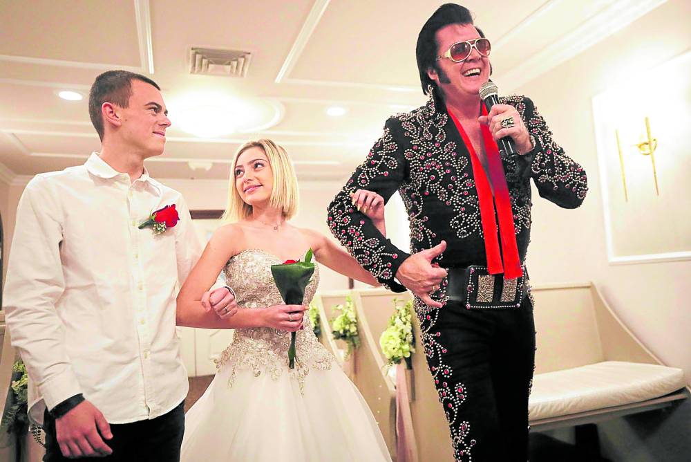 Elvis impersonator Brendan Paul sings during a “commitment ceremony” for a couple from France at the Graceland Wedding Chapel in Las Vegas, Nevada