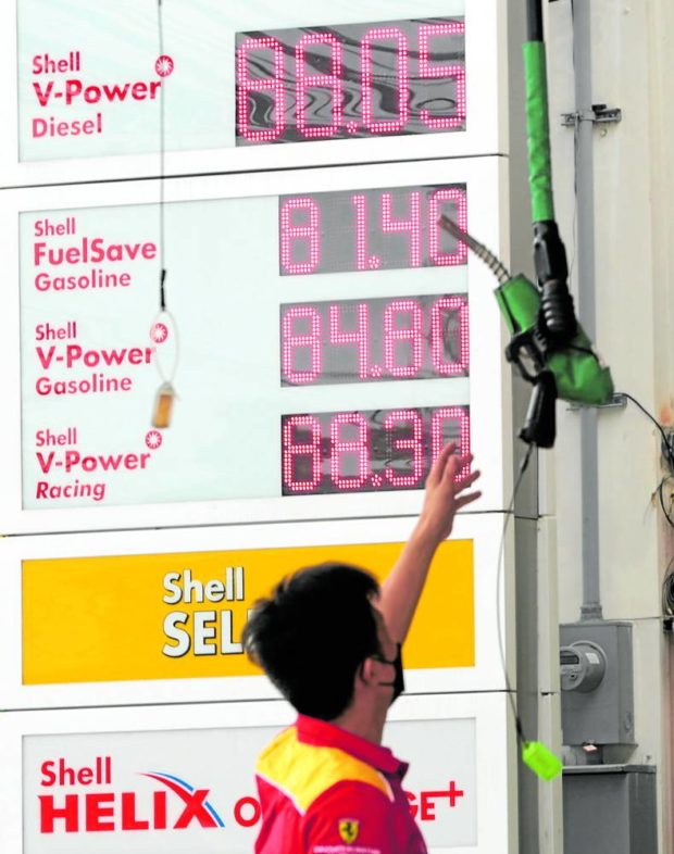 HIGHER AND HIGHER A service attendant reaches for a fuel pump at a gasoline station along Edsa in Quezon City on Tuesday, the day oil companies implemented the latest in a series of price increases to the detriment of drivers and commuters. —GRIG C. MONTEGRANDE