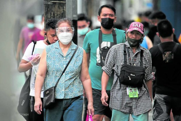 People walking outside wearing face masks. STORY: 83% of Filipinos hopeful worst is over with COVID-19 – SWS