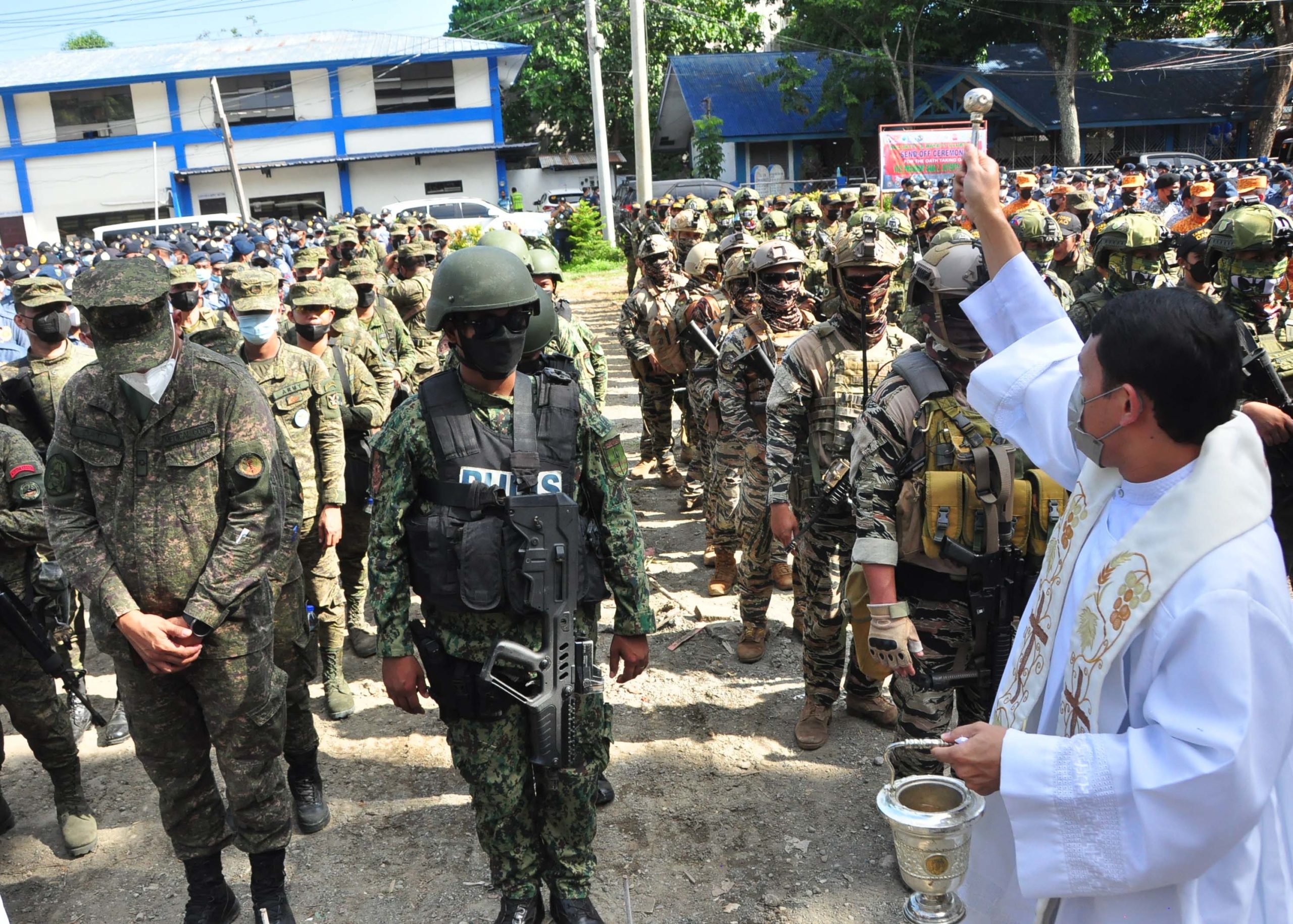 A priest blesses troops during the send-off ceremony Friday afternoon at the Davao City Police Office grounds