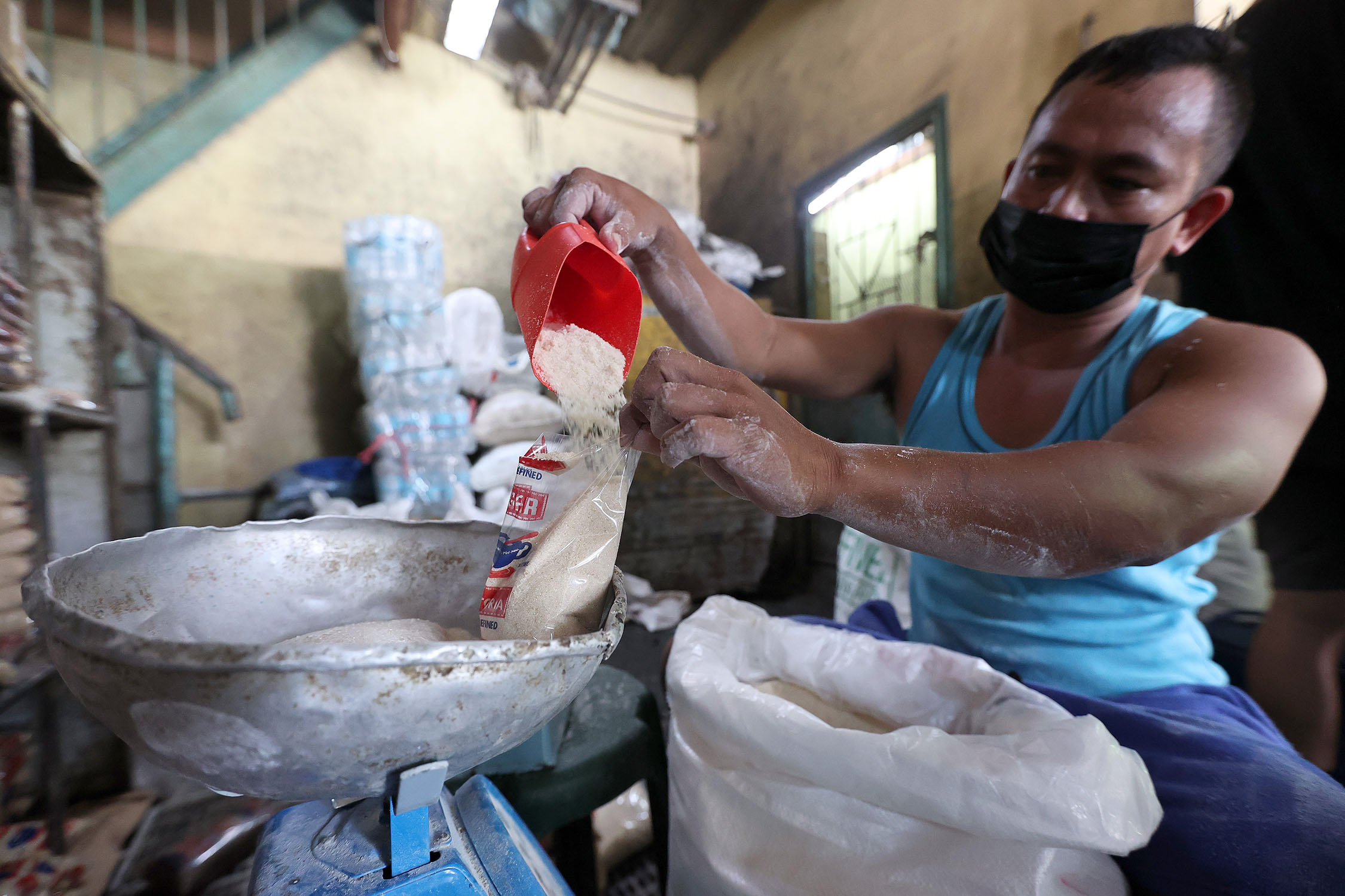 SUGAR SHORTAGE / MAY 27, 2022 Arnel Pongyan, 36, repacks sugar at a stall in Tandang Sora Public Market on Friday, May 27, 2022. The Sugar Regulatory Administration (SRA) said the sugar shortage is brought about by the damaged caused by typhoon Odette in Negros which caused prices to spike. INQUIRER PHOTO / GRIG C. MONTEGRANDE