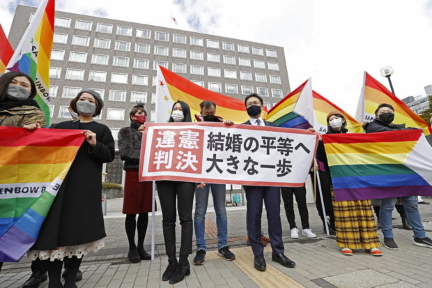 Plaintiffs' lawyers and supporters show a banner that reads 'Unconstitutional decision' after a district court ruled on the legality of same-sex marriages outside Sapporo district court in Sapporo, Hokkaido, northern Japan March 17, 2021, in this photo taken by Kyodo. Mandatory credit Kyodo/via REUTERS