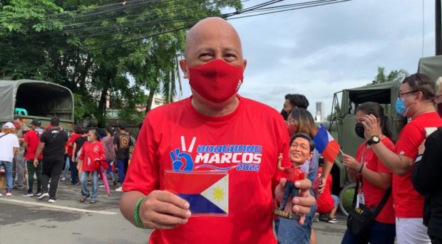 Clad in his Bongbong Marcos shirt, Mike dela Cruz shows off his other Marcos-related memorabilia
