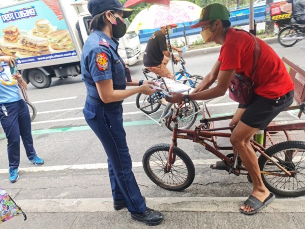 LOOK: Cops give away goodies as protest happens inside Bantayog ng mga Bayani