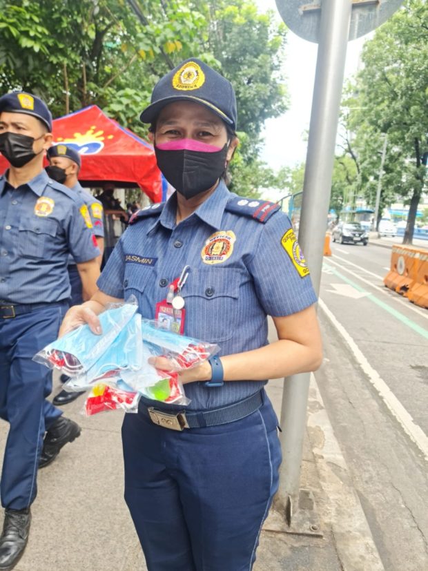 LOOK: Cops give away goodies as protest happens inside Bantayog ng mga Bayani