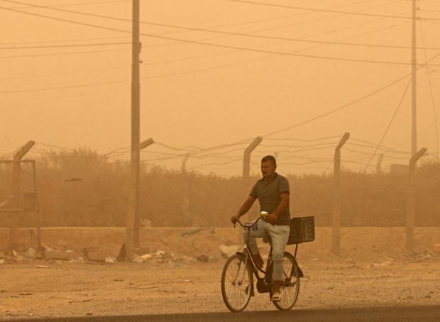 Weathering sandstorms, Iraqis grit teeth and battle on