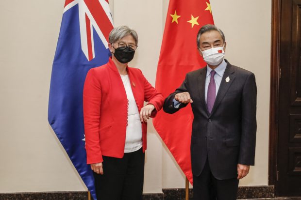 Australia's Foreign Minister Penny Wong (L) bumps elbows with China's Foreign Minister Wang Yi during their bilateral meeting on the sidelines of G20 Foreign Ministers Meeting in Nusa Dua on Indonesia's resort island of Bali on July 8, 2022. (Photo by Johannes P. CHRISTO / POOL / AFP)