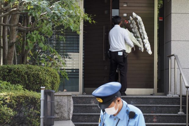 A man carries flowers at the residence of former Japanese prime minister Shinzo Abe in Tokyo on July 9, 2022. - World leaders have recoiled in horror after Japan's former prime minister Shinzo Abe was shot dead during a campaign speech on July 8 -- an especially shocking assassination given the country's strict gun laws and low rates of violent crime. (Photo by TOSHIFUMI KITAMURA / AFP)
