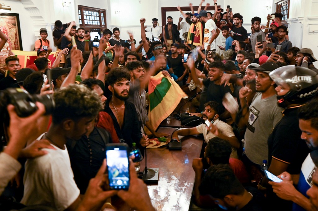Demonstrators shout slogans inside the office building of Sri Lanka's prime minister during an anti-government protest in Colombo on July 13, 2022. - Thousands of anti-government protesters stormed into Sri Lanka Prime Minister Ranil Wickremesinghe's office on July 13, hours after he was named as acting president, witnesses said. (Photo by Arun SANKAR / AFP) crisis Rajapaksa