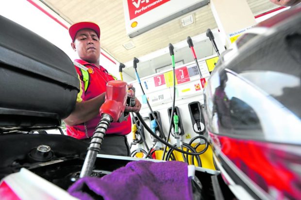 Man filling up car with gasoline at service station. STORY: Fuel price rollback expected next week