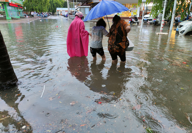 Pedestrians wade through floodwaters on a street as Typhoon Chaba hits Sanya. STORY: China lashed by year’s first typhoon, record rainfall forecast