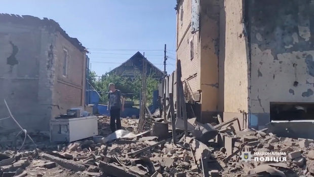 A man walks in the rubble near damaged buildings, as Russia's invasion of Ukraine continues, in Bakhmut, Donetsk Oblast, Ukraine in this still image obtained from a social media video released on July 2, 2022. National Police of Ukraine/Handout via REUTERS
