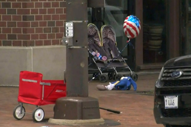 A child's stroller with a stars and stripes balloon attached is left after gunfire erupted at a Fourth of July parade route in the wealthy Chicago suburb of Highland Park, Illinois, U.S. July 4, 2022 in a still image from video. ABC affiliate WLS/ABC7 via REUTERS