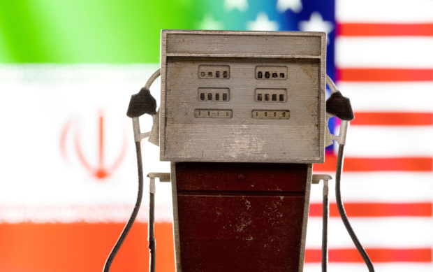 The photo shows a model petrol pump seen in front of US and Iran flag colors with the US imposing sanctions on a network of Chinese, Emirati, and other companies that it accused of helping to deliver and sell Iranian petroleum