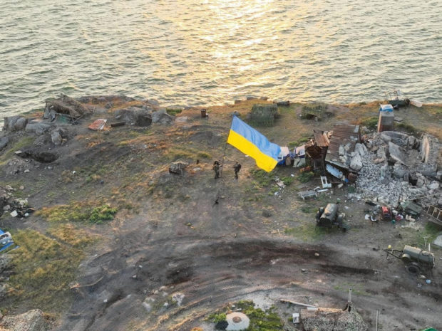 Ukrainian service members install a national flag on Snake (Zmiinyi) Island, as Russia's attack on Ukraine continues, in Odesa region, Ukraine, in this handout picture released July 7, 2022. Press service of the Ukrainian Armed Forces/Handout via REUTERS