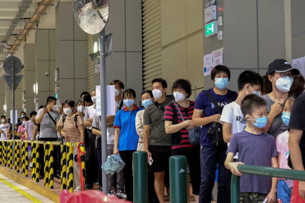 Residents wearing face masks line up to get tested for the coronavirus disease (COVID-19) in Macau, China July 4, 2022. REUTERS/John Mak