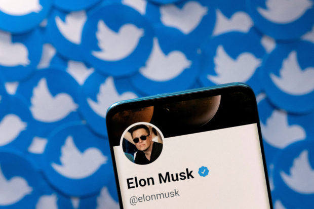 Elon Musk's Twitter profile is seen on a smartphone placed on printed Twitter logos in this picture illustration taken April 28, 2022. REUTERS/Dado Ruvic/Illustration/