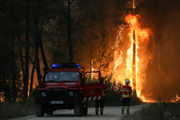 Firefighters watch a wildfire in Ourem, Santarem district in Portugal as scorching heatwave sparks wildfires in Europe
