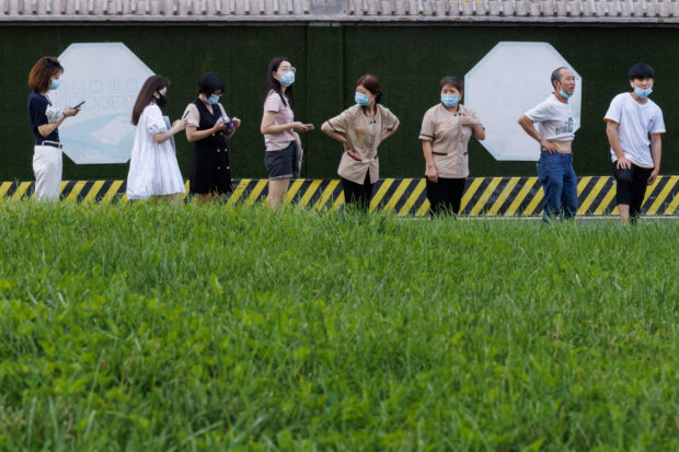 People line up at a nucleic acid testing station, following a coronavirus disease (COVID-19) outbreak, in Beijing, China, July 14, 2022. REUTERS/Thomas Peter