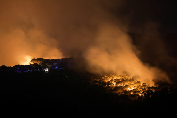 A wildfire burns during night-time in Alhaurin el Grande, southern Spain, July 16, 2022. REUTERS/Jon Nazca