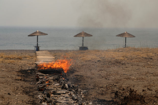 A wooden beach bar corridor burns as wildfire rages near the village of Vatera, on the island of Lesbos, Greece July 23, 2022. REUTERS/Elias Marcou