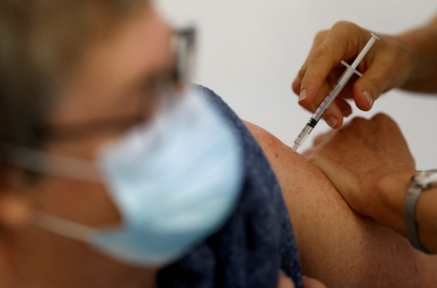 FILE PHOTO: A medical worker administers a dose of the "Cominarty" Pfizer-BioNTech coronavirus disease (COVID-19) vaccine to a patient at a vaccination center in Ancenis-Saint-Gereon, France, November 17, 2021. REUTERS/Stephane Mahe/File Photo/File Photo