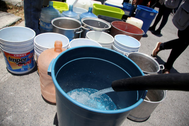 FILE PHOTO: Buckets are refilled with water by residents as a water truck distributes it outside houses at La Hacienda neighborhood in Guadalupe, in Nuevo Leon state, Mexico June 11, 2022. REUTERS/Jorge Mendoza
