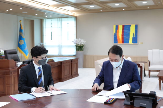 Justice Minister Han Dong-hoon (left) briefs President Yoon Suk-yeol 