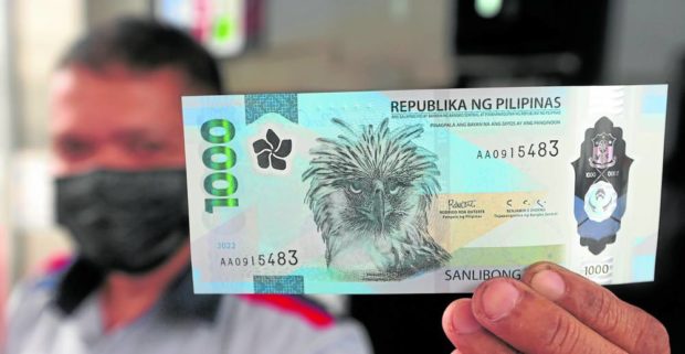 Man holding up a 1,000-peso polymer bill. STORY: BSP: OK to fold new P1,000 bills
