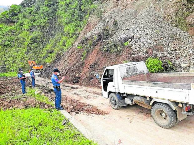 Policemen in Banaue, Ifugao province, on Tuesday assist motorists through a reopened section of the Banaue-Hungduan-Benguet boundary road.