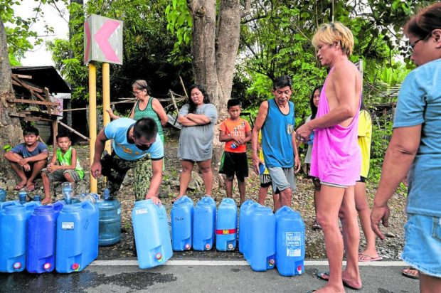 Residents affected by the July 27 earthquake in Bangued, Abra, wait in line for their water supply. STORY: Folk displaced by earthquake hit 33,000; injured at 320