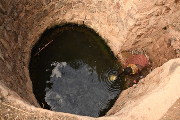 A woman fetches water from a well in the Loiyangalani area where families affected by the prolonged drought are hosted, at Parapul village, in Marsabit, northern Kenya, on July 11, 2022. 
