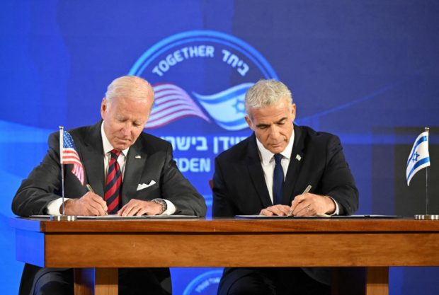 US President Joe Biden (L) and Israel's caretaker Prime Minister Yair Lapid, sign a security pledge in Jerusalem, on July 14, 2022. 