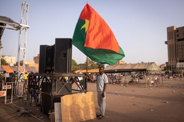 A man holds a Burkina's flag during a gathering to show support to the military in Ouagadougou, on February 19, 2022. 