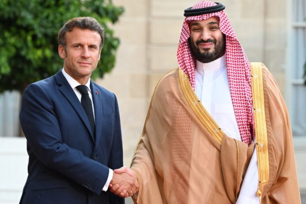 France's President Emmanuel Macron greets Saudi Crown Prince Mohammed bin Salman as he arrives at presidential Elysee Palace in Paris on July 28, 2022. -