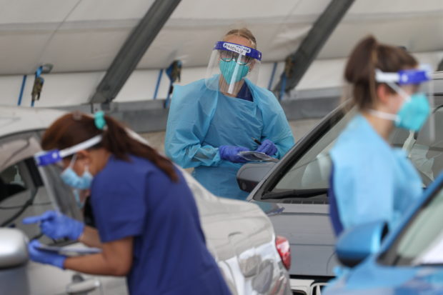Medical workers administer tests at a drive-through COVID-19 testing centre in Sydney