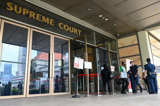 People enter the Supreme Court in Singapore on March 1, 2022, as the city state's top court hears a last-ditch appeal of a Malaysian man facing execution over drug trafficking charges despite concerns he is mentally disabled.