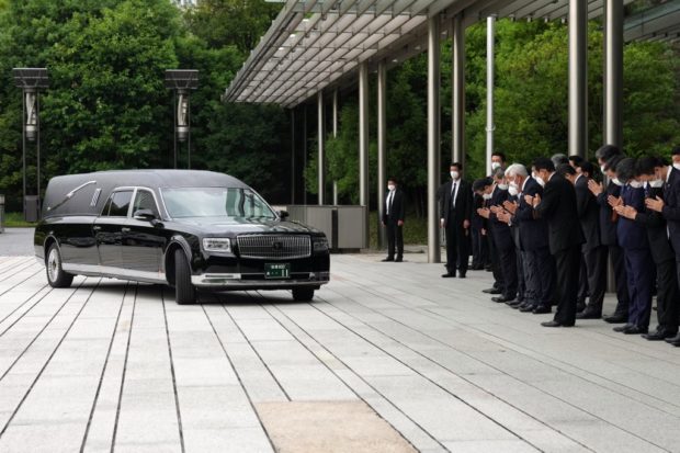 A hearse transporting the body of Japan's former prime minister Shinzo Abe makes a brief visit to the Prime Minister's Office after the funeral ceremony, as Japan's Prime Minister Fumio Kishida, officials and employees offer prayers in Tokyo on July 12, 2022. 