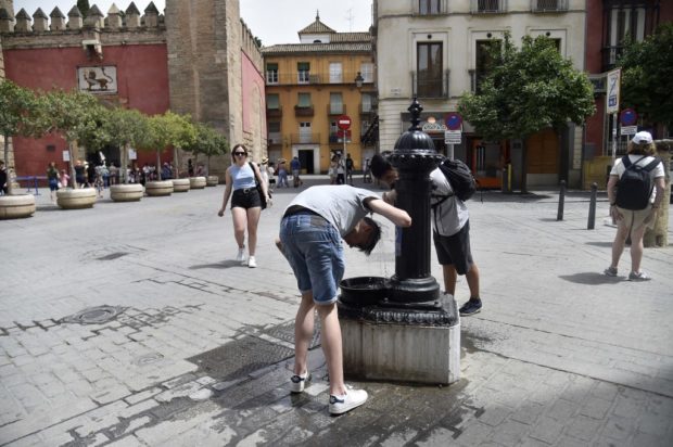 People cool off to fight the scorching heat during a heatwave in Seville on June 13, 2022.