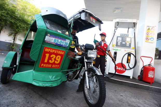 Tricycle at gas station. STORY: Another fuel price hike seen amid fears of global recession