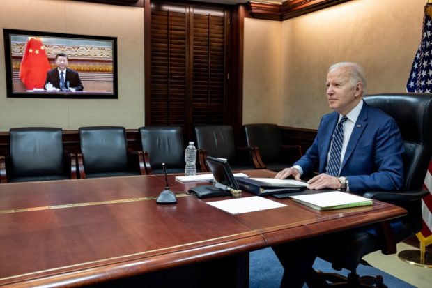 In this image released by the White House, US President Joe Biden (L) speaks with Chinese President Xi Jinping (on screen) from the White House in Washington, DC, on March 18, 2022