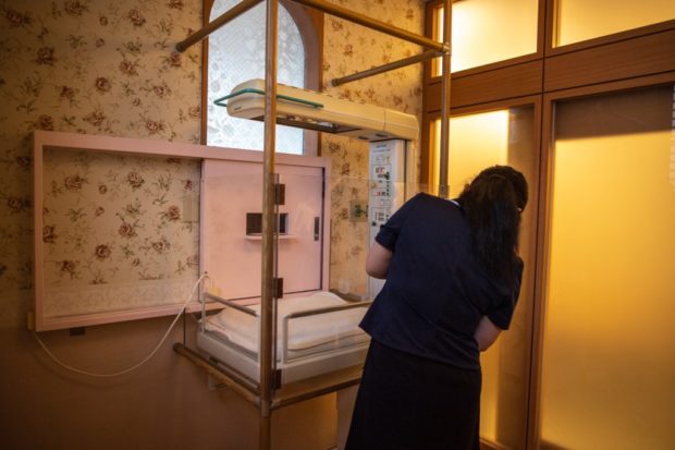 In this picture taken on June 10, 2022, a staff member demonstrates the baby hatch room at Jikei hospital in Kumamoto. - 