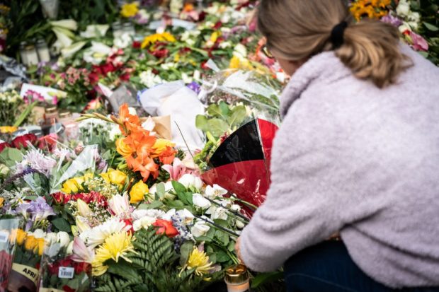 A women lays flowers before a memorial service in front of the Field's shopping center, two days after a shooting, in Copenhagen, Denmark, on July 5, 2022. 