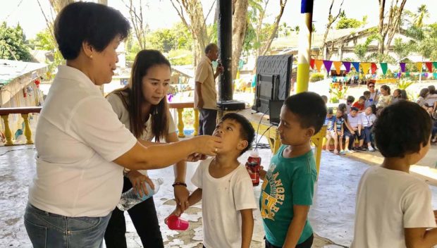Teachers and health workers give children in Santa Rosa, Laguna deworming medicines. PHOTO FROM FACEBOOK PAGE OF APLAYA ELEMENTARY SCHOOL