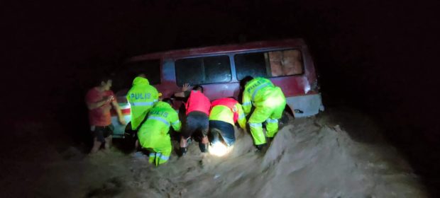 Policemen in Banaue town, Ifugao province try to prevent a van from getting swept away in a flash flood that was triggered by the heavy rains