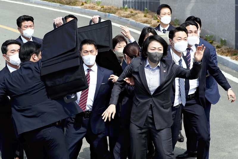 Security personnel and others protect former South Korean President Park Geun-hye