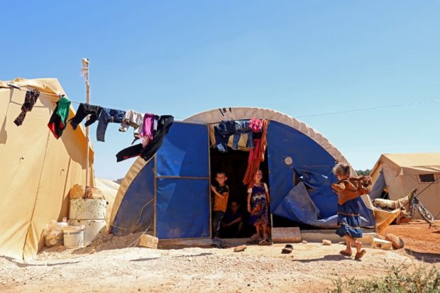 Children play at a camp for Syrians displaced by conflict near the Syrian border with Turkey in the rebel-held northern part of the northwestern Idlib province amidst high temperatures on July 20, 2022. 