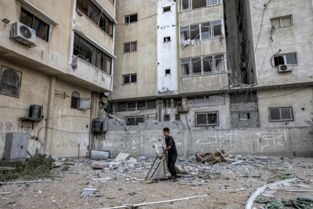 A boy inspects damage caused by an Israeli air strike in the vicinity of the 'Palestine Tower' in Gaza City, on August 6, 2022. - Israel hit Gaza with air strikes and the Palestinian Islamic Jihad militant group retaliated with a barrage of rocket fire, in the territory's worst escalation of violence since a war last year. Israel has said it was forced to launch a "pre-emptive" operation against Islamic Jihad, insisting the group was planning an imminent attack following days of tensions along the Gaza border. (Photo by MAHMUD HAMS / AFP)